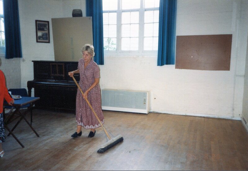 Barbara Buchs sweeping the village hall floor