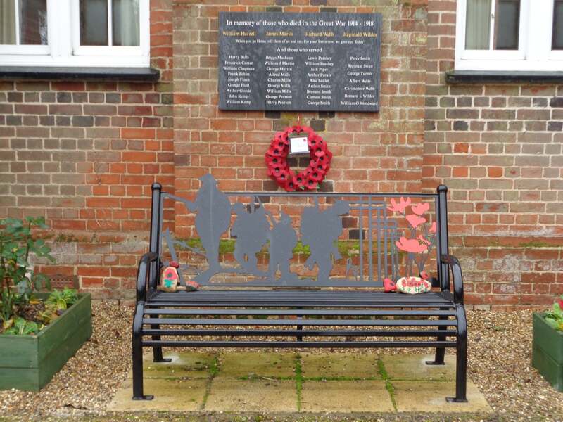 bench and war memorial outside village hall